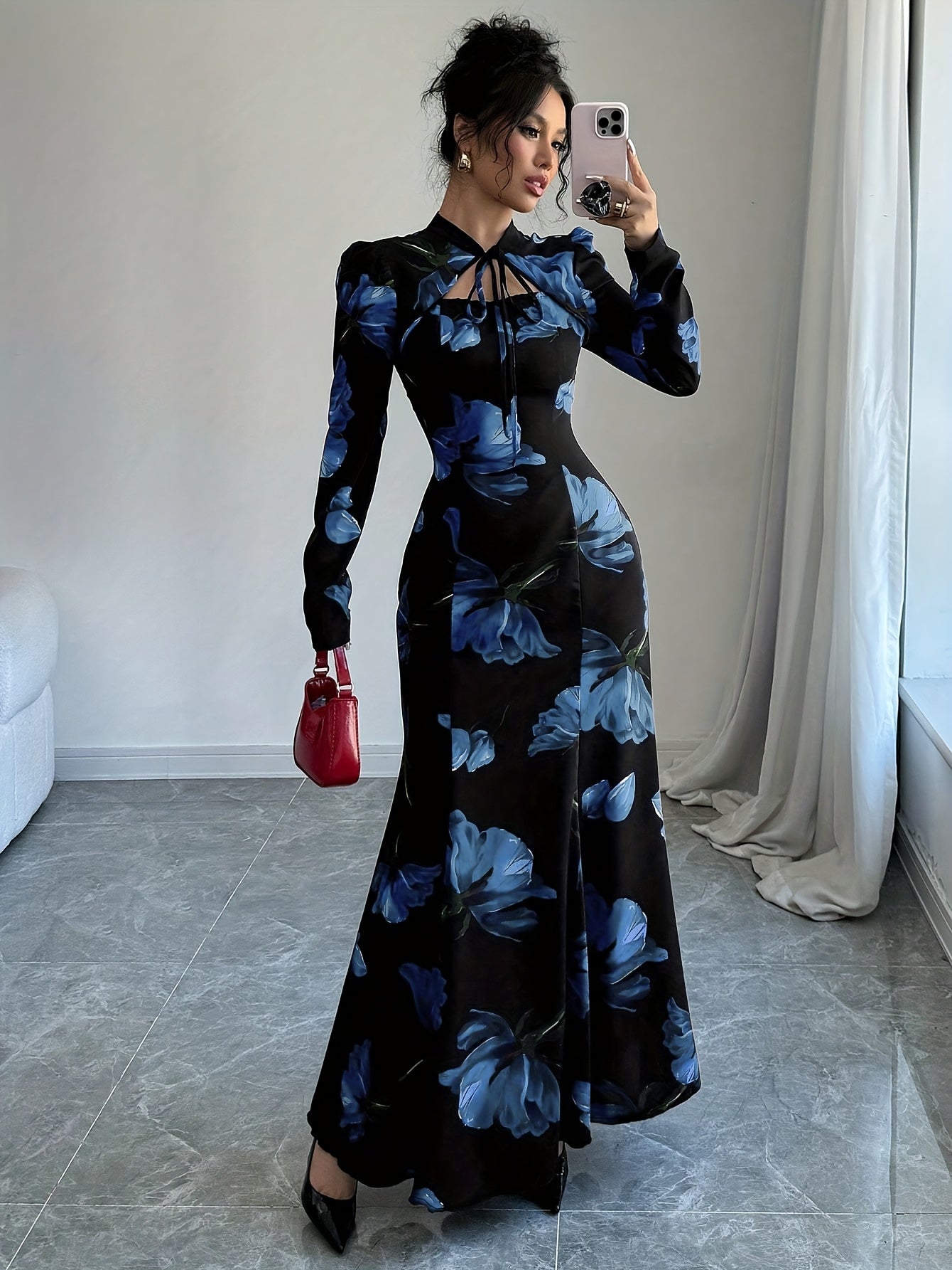 Robe maxi élégante à imprimé floral – manches longues, détail nœud au dos, taille cintrée, ourlet asymétrique, noire avec fleurs bleues, idéale automne/hiver, mode femme adulte, robe fleurie