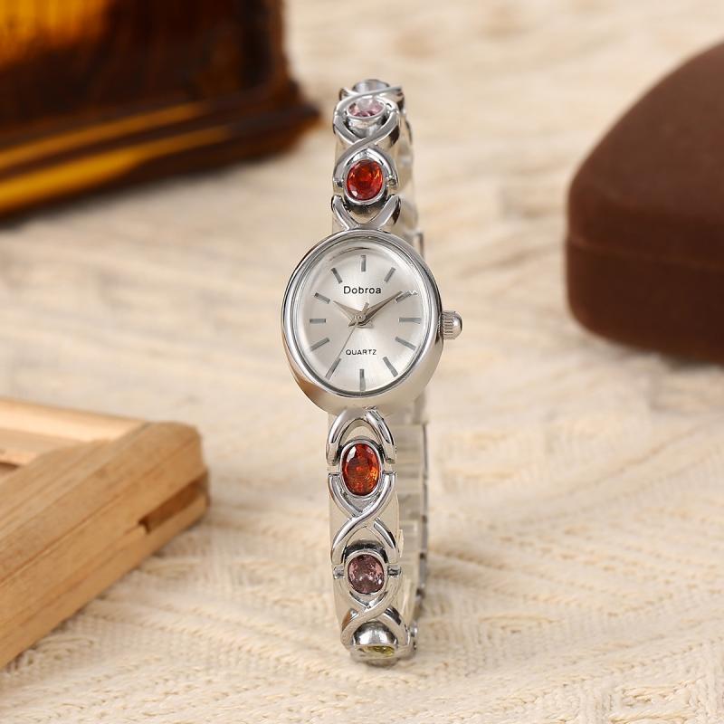 Montre Femme Élégante –Boîtier Ovale Ton Doré avec Strass Synthétiques Colorés, Cadran Blanc Analogique, Style Bracelet Classique et Luxueux, Cadeau Idéal pour Noël, Saint-Valentin ou Autres Occasions