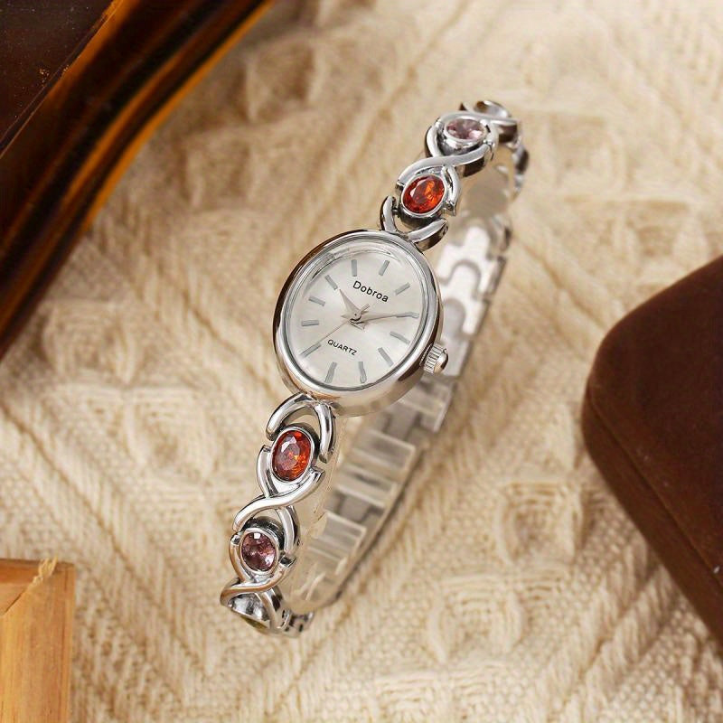 Montre Femme Élégante –Boîtier Ovale Ton Doré avec Strass Synthétiques Colorés, Cadran Blanc Analogique, Style Bracelet Classique et Luxueux, Cadeau Idéal pour Noël, Saint-Valentin ou Autres Occasions