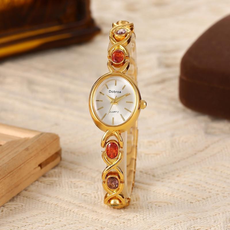 Montre Femme Élégante –Boîtier Ovale Ton Doré avec Strass Synthétiques Colorés, Cadran Blanc Analogique, Style Bracelet Classique et Luxueux, Cadeau Idéal pour Noël, Saint-Valentin ou Autres Occasions
